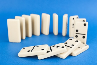 White domino tiles falling on blue background