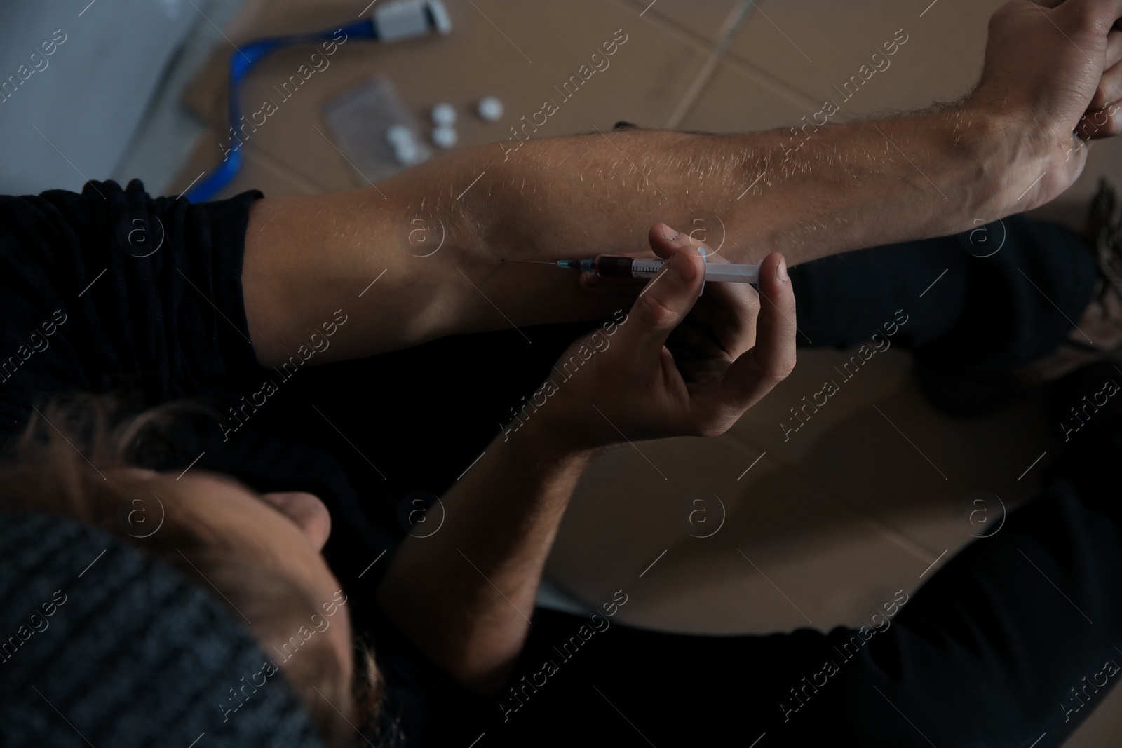 Photo of Male drug addict making injection, above view