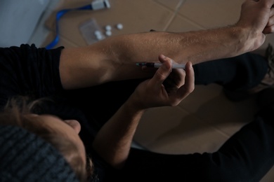 Photo of Male drug addict making injection, above view