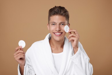 Photo of Handsome man with cotton pads on beige background