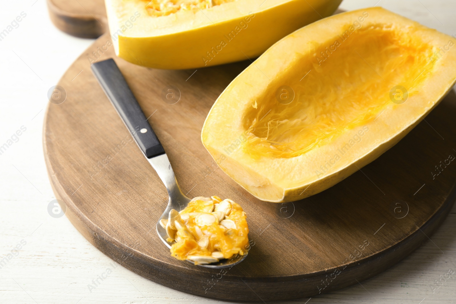 Photo of Cut spaghetti squash and spoon on wooden table