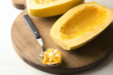 Photo of Cut spaghetti squash and spoon on wooden table