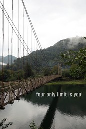 Image of Your only limit is you, affirmation. Rusty metal bridge over river in mountains
