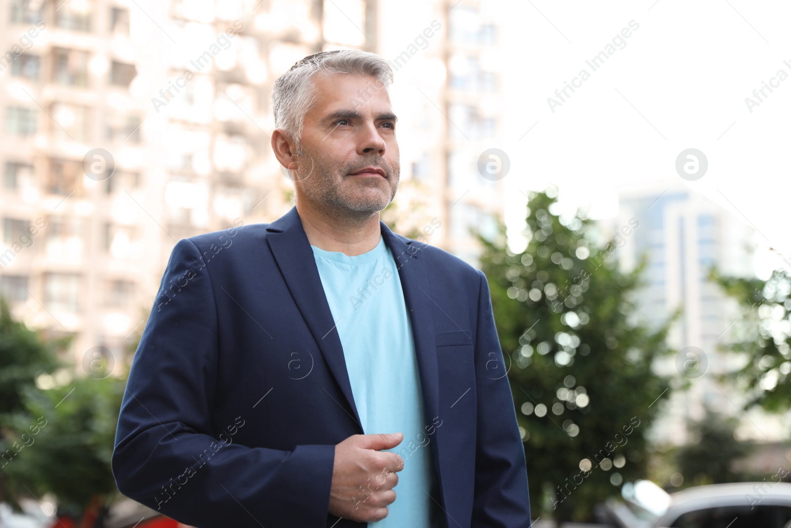 Photo of Portrait of handsome mature man in city center. Space for text