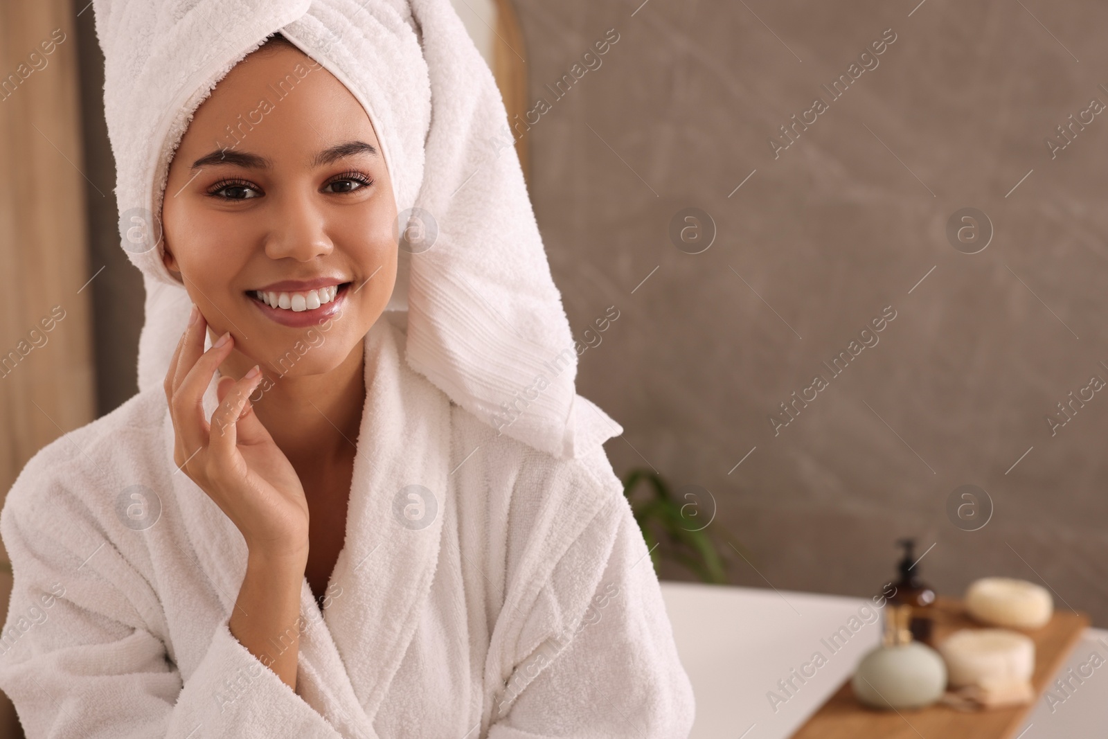 Photo of Beautiful African American woman in bathroom, space for text