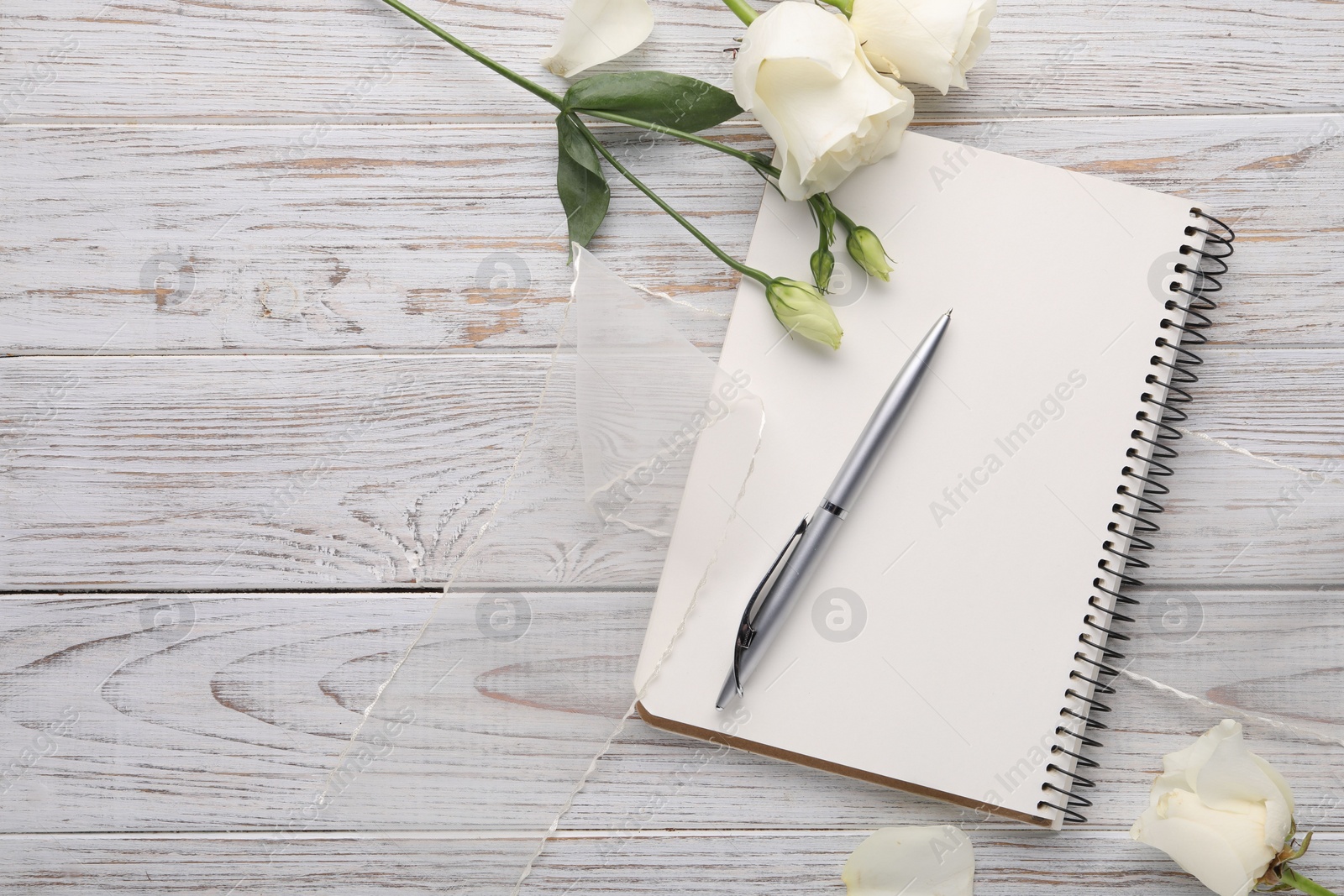 Photo of Guest list. Notebook, pen, rose flowers and ribbon on wooden background, flat lay. Space for text