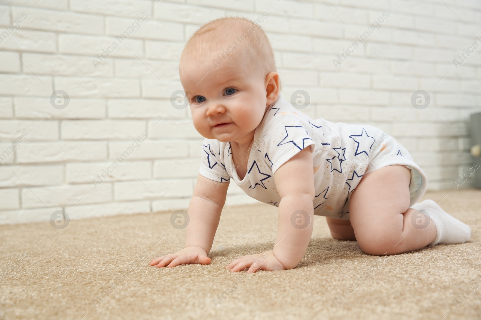 Photo of Cute little baby crawling on carpet indoors, space for text