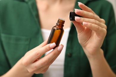 Photo of Aromatherapy. Woman with bottle of essential oil, closeup