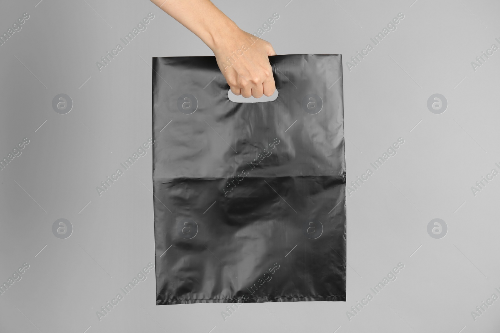 Photo of Woman with plastic bag on grey background. Mock up for design