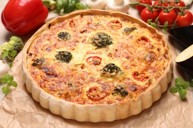 Photo of Delicious homemade vegetable quiche on parchment paper, closeup