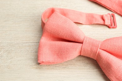 Photo of Stylish pink bow tie on wooden background, closeup