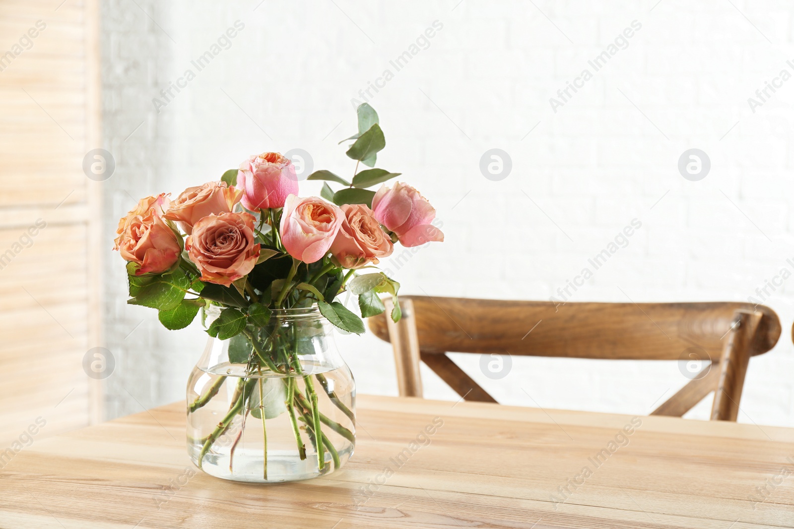 Photo of Vase with beautiful flowers as element of interior design on table in room. Space for text