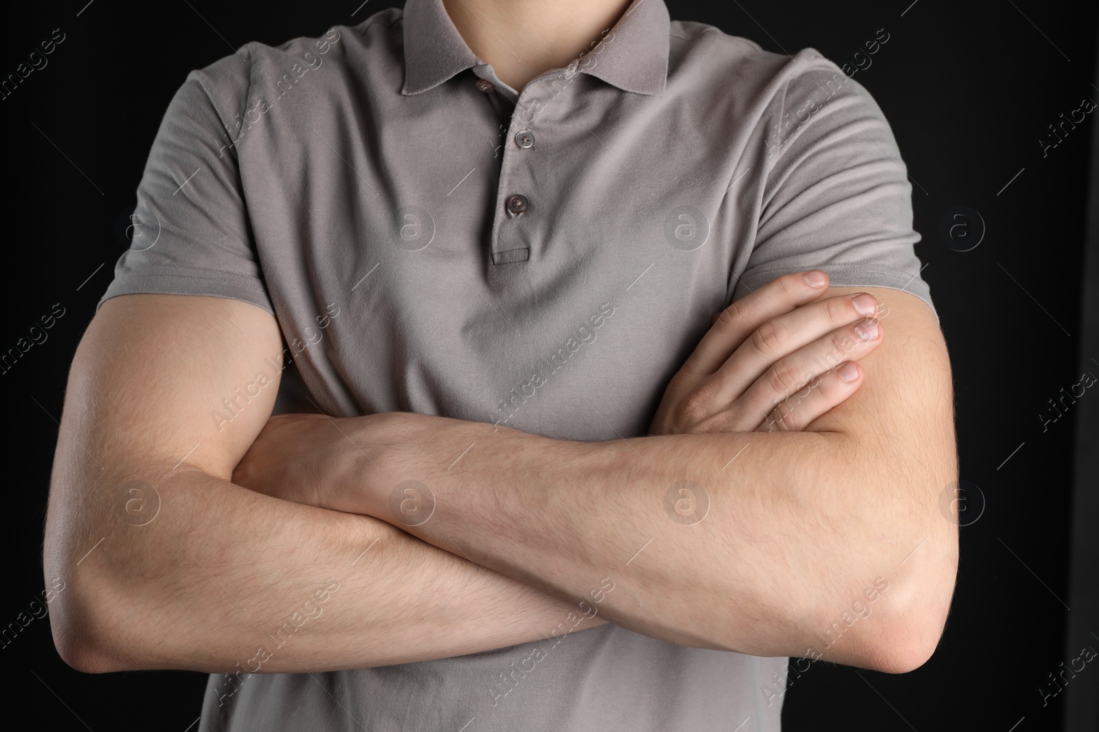 Photo of Man with space for tattoo on his arms against black background, closeup