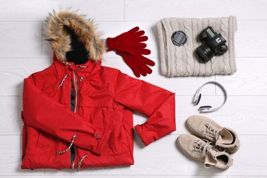 Flat lay composition with warm clothes for winter vacation on wooden background