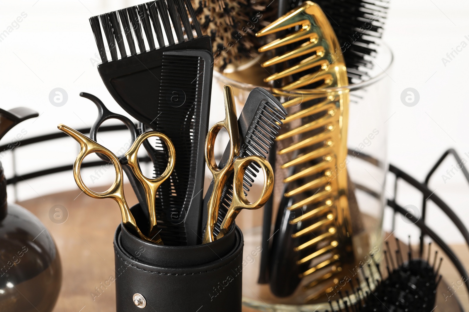 Photo of Set of hairdresser tools on table in salon, closeup