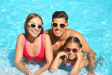 Happy family in swimming pool on sunny day