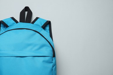 Photo of One blue backpack on light background, top view. Space for text