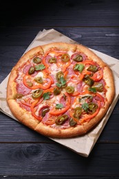 Photo of Delicious pizza Diablo on black wooden table