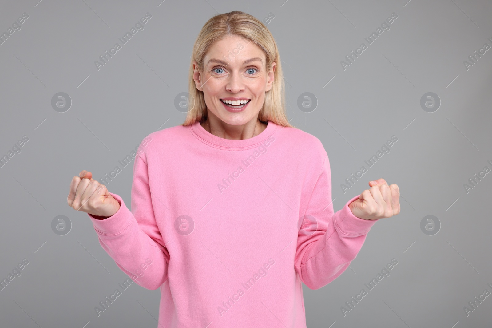 Photo of Portrait of happy surprised woman on grey background