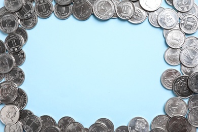 Frame of Ukrainian coins on light blue background, flat lay. Space for text