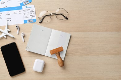 Photo of Flat lay composition with passport, stamp and flight tickets on wooden table, space for text