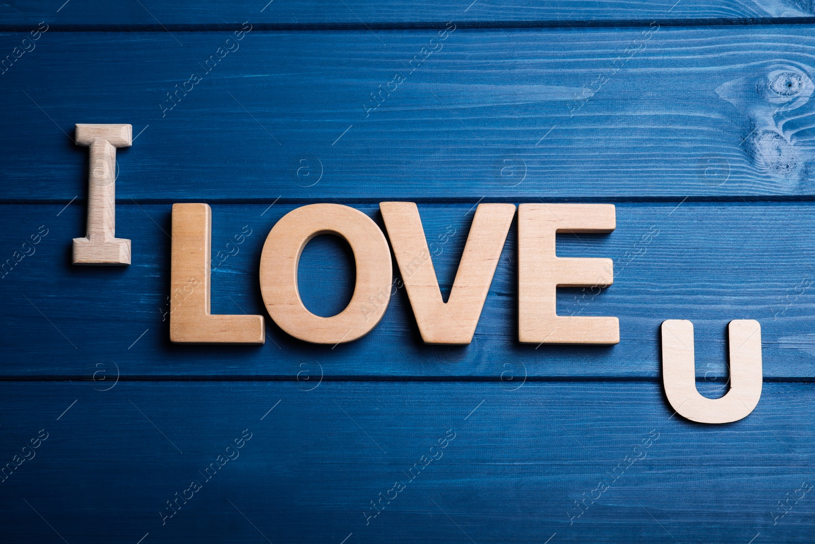 Photo of Phrase I Love U on blue wooden background, flat lay