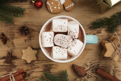 Flat lay composition with delicious marshmallow cocoa and Christmas decor on wooden table