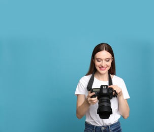 Photo of Professional photographer with modern camera on light blue background. Space for text