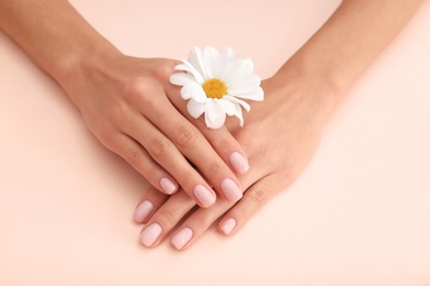 Closeup view of woman with flower on color background. Spa treatment