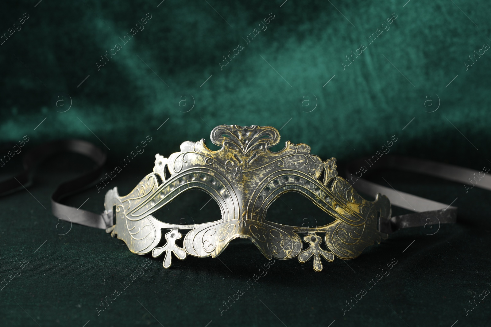 Photo of Theater arts. Venetian carnival mask on green fabric