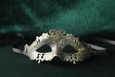Photo of Theater arts. Venetian carnival mask on green fabric