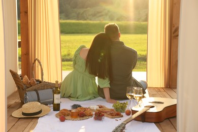 Photo of Romantic date. Couple spending time together during picnic on sunny day, back view