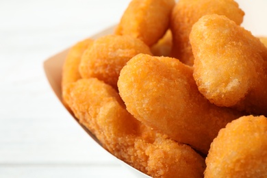 Tasty fried chicken nuggets on white background, closeup