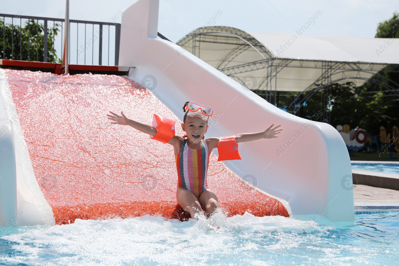 Photo of Cute little girl on slide in water park