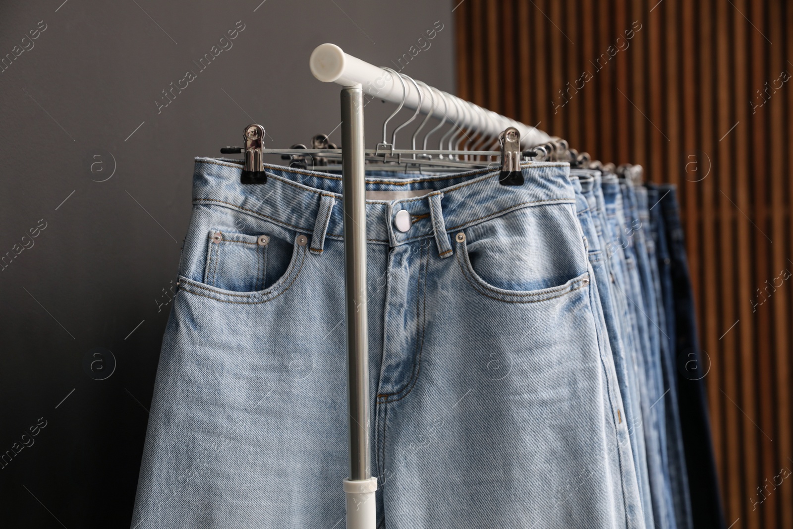 Photo of Rack with different stylish jeans, closeup view