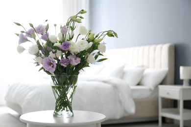 Photo of Beautiful bouquet with Eustoma flowers on table in bedroom. Space for text