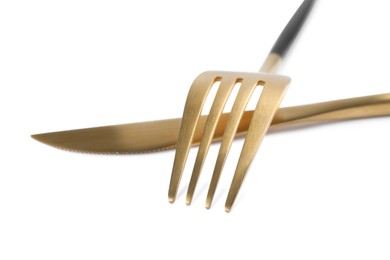 Photo of New golden fork and knife on white background, closeup
