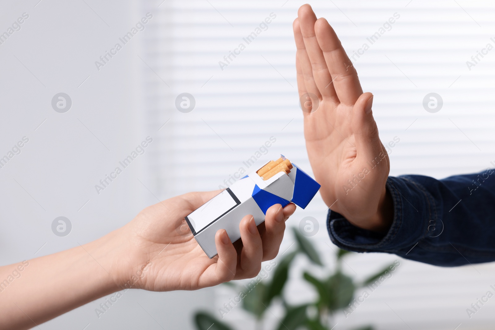 Photo of Woman refusing cigarettes at home, closeup. Quitting smoking concept