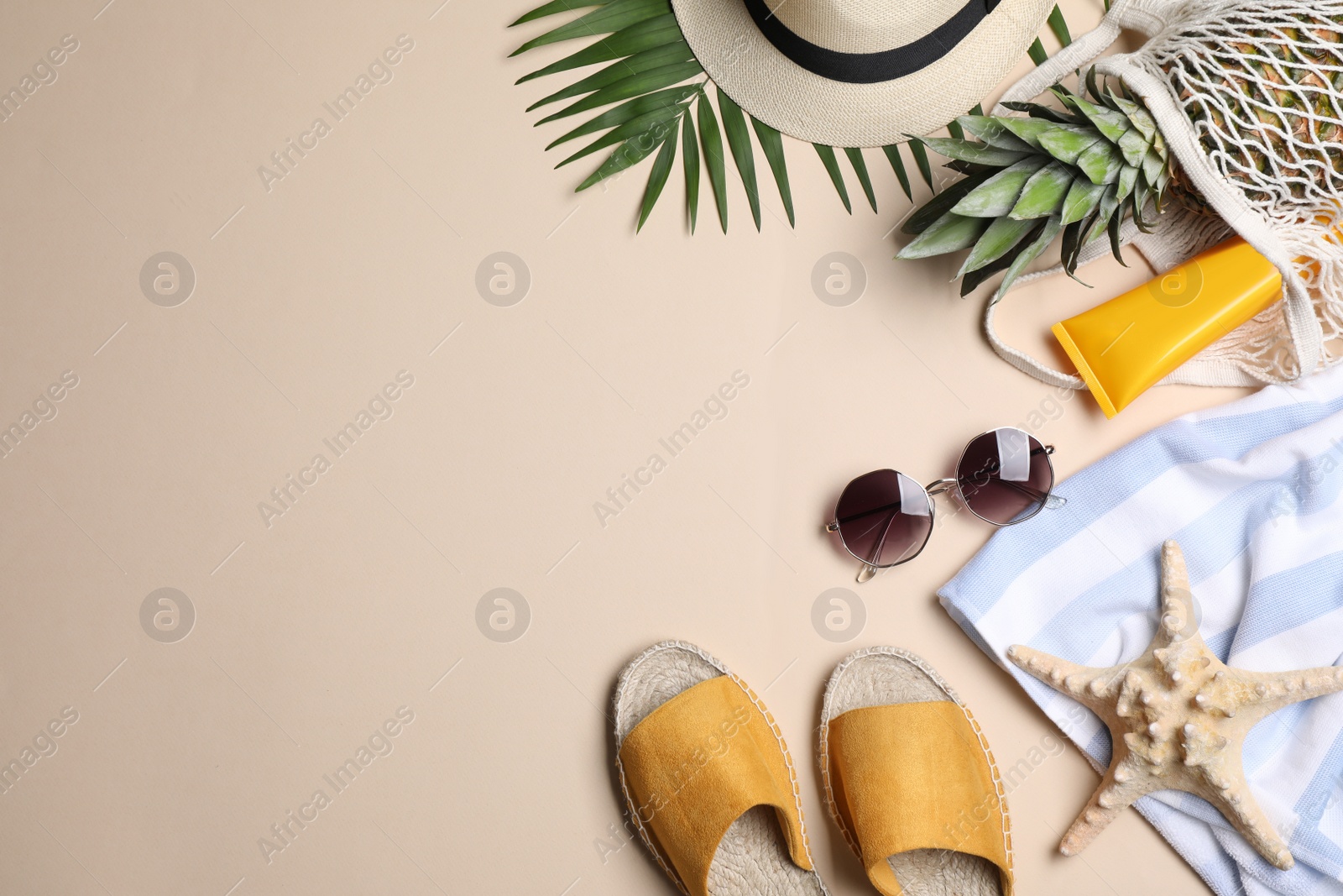 Photo of Beach accessories on beige background, flat lay. Space for text