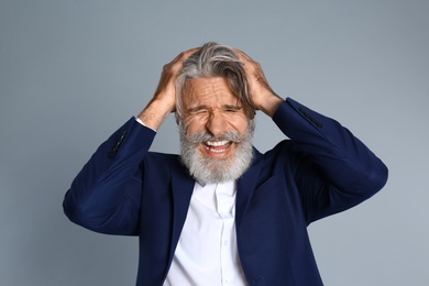 Photo of Man suffering from headache on grey background