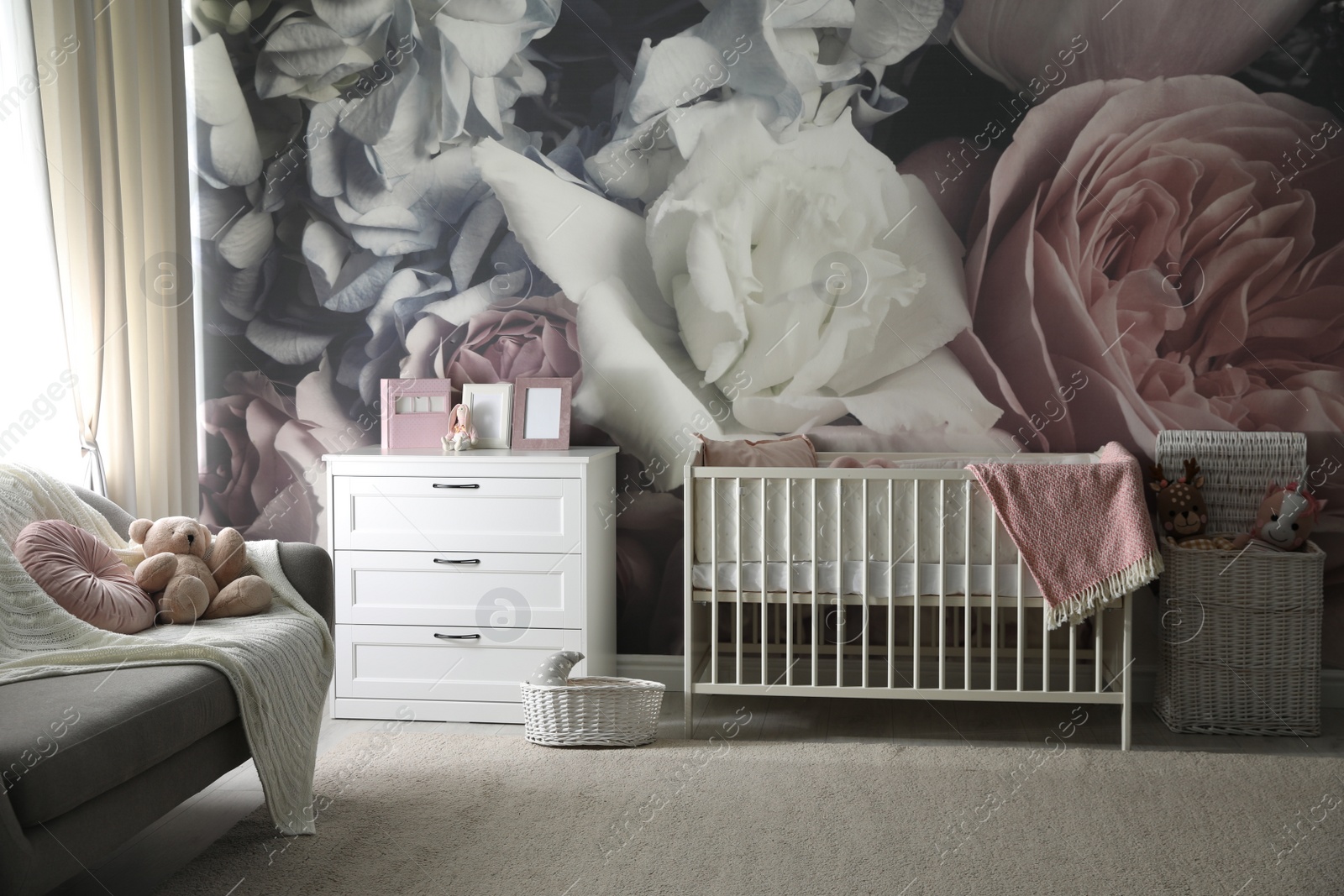 Photo of Baby room interior with stylish crib and floral wallpaper