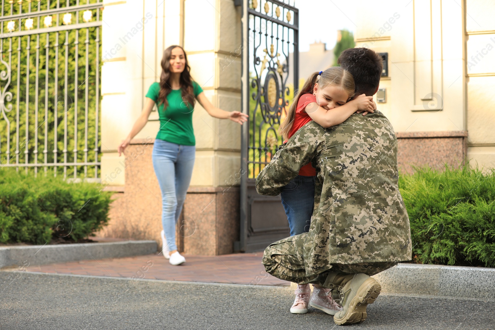 Photo of Man in military uniform and his family outdoors