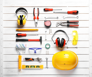 Flat lay composition with different construction tools on white wooden background