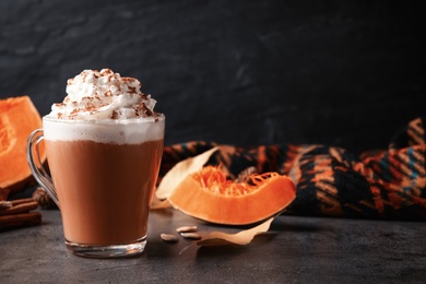 Delicious pumpkin latte on grey table, closeup