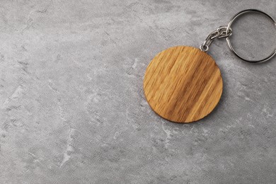 Wooden keychain in shape of smiley face on grey background, top view. Space for text