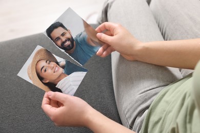 Photo of Woman holding torn photo on sofa indoors, closeup. Divorce concept