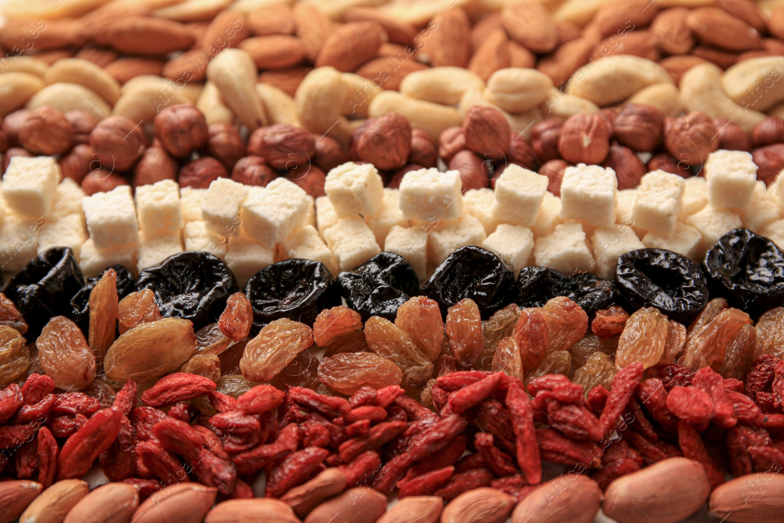 Photo of Different tasty nuts and dried fruits on beige background