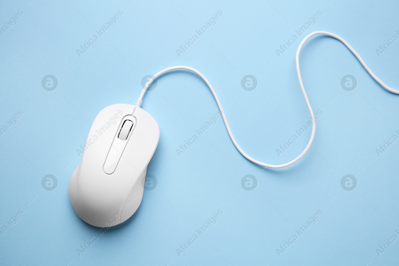 Photo of One wired mouse on light blue background, top view