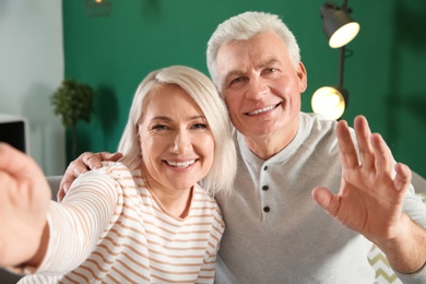 Photo of Mature couple using video chat at home, view from web camera