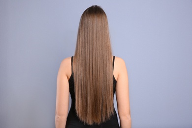 Photo of Young woman with long beautiful hair on grey background
